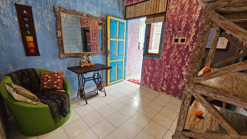 a living room with a green chair and a mirror at Lovina Loca in Lovina