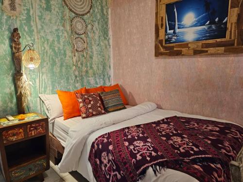 a bedroom with a bed and a table with a mirror at Lovina Loca in Lovina