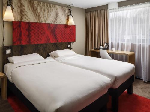 a hotel room with a large bed in a room at Ibis Casablanca Sidi Maarouf in Casablanca