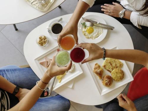a group of people sitting around a table eating food at Ibis Casablanca Sidi Maarouf in Casablanca