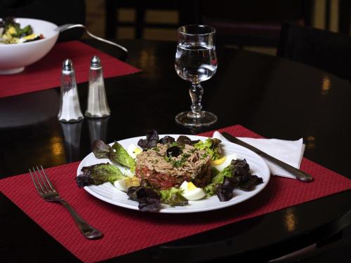 a plate of food on a table with a glass of wine at Ibis Marrakech Palmeraie in Marrakech