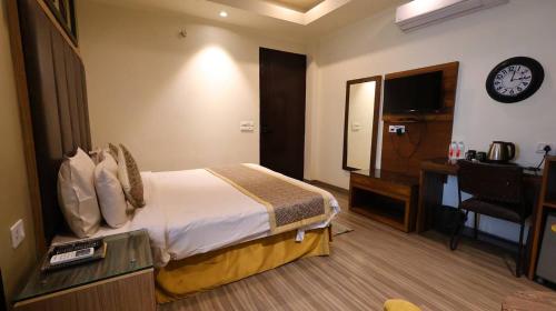 a hotel room with a bed and a clock on the wall at Hotel Imperial Park in Gurgaon