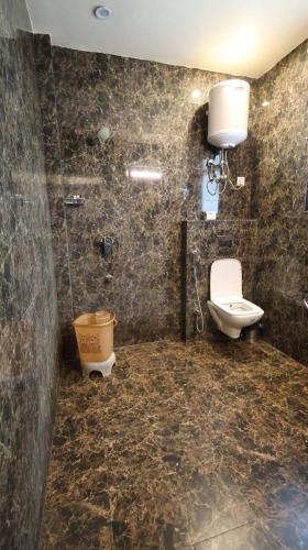 a bathroom with a toilet and a shower and a sink at Hotel Imperial Park in Gurgaon