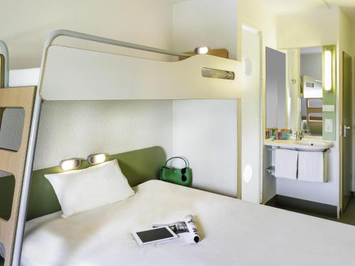 a room with a bed with a camera on it at ibis budget Flensburg Handewitt in Handewitt