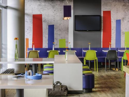 a conference room with tables and chairs and a tv at ibis budget Flensburg Handewitt in Handewitt