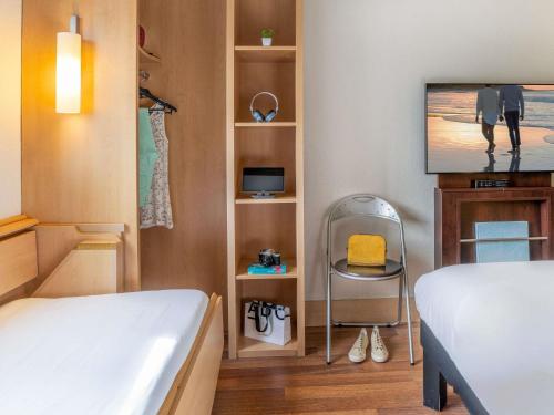 a small room with a bed and a tv at Ibis Madrid Alcobendas in Alcobendas