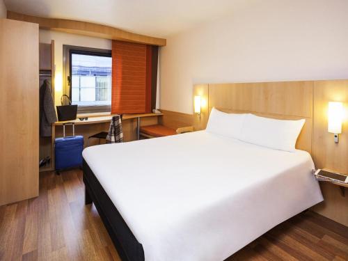 a bedroom with a large white bed and a desk at Ibis Madrid Alcobendas in Alcobendas