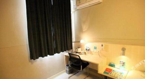 a room with a desk with a chair and a heater at JinJiang Inn Nanchang Bayi Square Ximazhuang Food Street in Nanchang