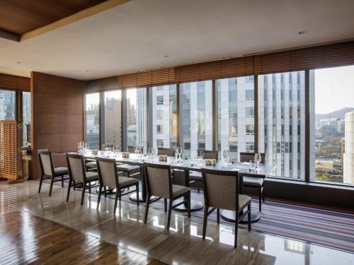 a dining room with a long table and chairs at Ibis Ambassador Myeongdong in Seoul