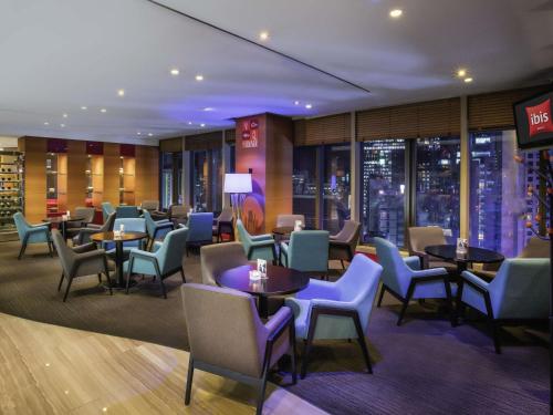 a restaurant with tables and chairs and a city skyline at Ibis Ambassador Myeongdong in Seoul