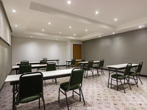 a conference room with tables and chairs and a wall at ibis Criciuma in Criciúma
