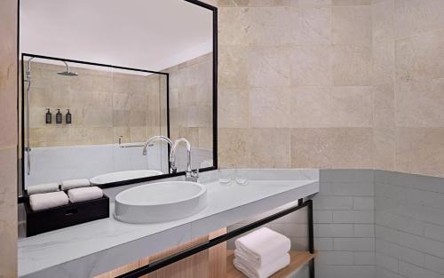 a bathroom with a sink and a large mirror at Sheraton Jakarta Soekarno Hatta Airport in Tangerang