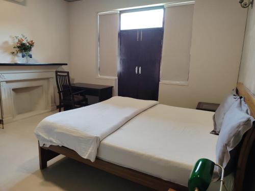 a bedroom with a bed and a fireplace and a window at Bali Mantra in New Delhi