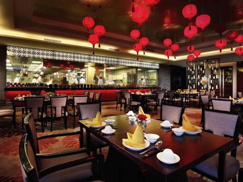 a dining room with tables and chairs and red lanterns at Sofitel Guangzhou Sunrich - Free Shuttle Bus to Canton Fair Complex & Overseas Buyer Registration Services during Canton Fair Period in Guangzhou