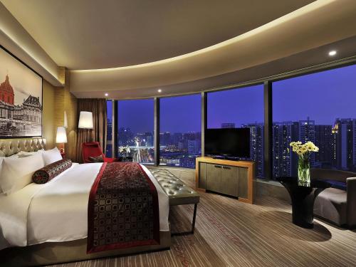 a hotel room with a large bed and a large window at Sofitel Guangzhou Sunrich - Free Shuttle Bus to Canton Fair Complex & Overseas Buyer Registration Services during Canton Fair Period in Guangzhou