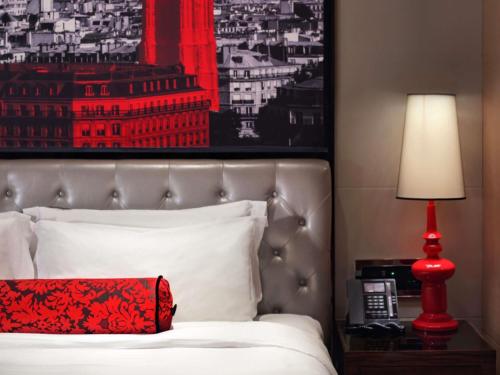 a bed with a red pillow and a red lamp at Sofitel Guangzhou Sunrich - Free Shuttle Bus to Canton Fair Complex & Overseas Buyer Registration Services during Canton Fair Period in Guangzhou