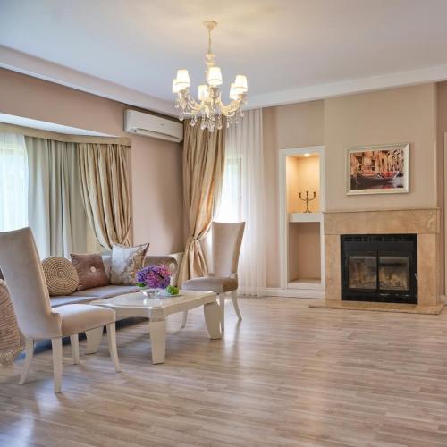 a living room with a couch and chairs and a fireplace at Hotel D Precesion Suites Near IGI Airport in New Delhi