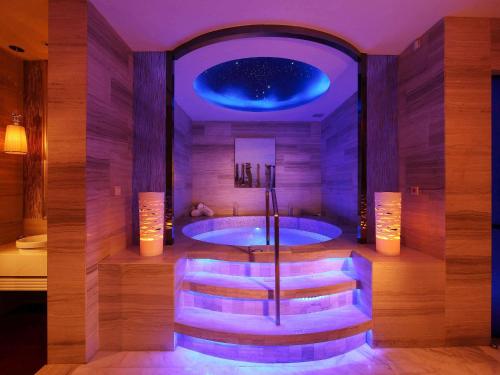 a large bathroom with a tub with a chair in it at Sofitel Guangzhou Sunrich - Free Shuttle Bus to Canton Fair Complex & Overseas Buyer Registration Services during Canton Fair Period in Guangzhou