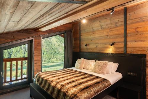 Un dormitorio con una cama en una cabaña de troncos en Black Diamond - Chalet Babylon, en Les Brévières