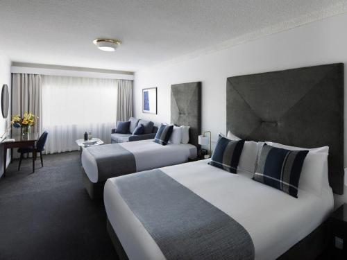 a hotel room with two beds and a couch at Peppers The Hills Lodge in Castle Hill