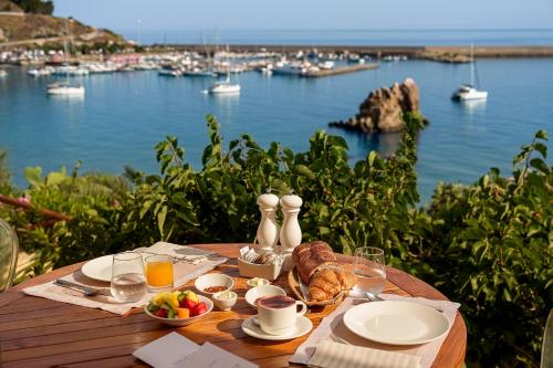 a table with food and a view of a harbor at Le Calette N.5 in Cefalù
