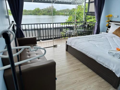 a bedroom with a bed and a view of a river at Riverside Hostel Phuket in Phuket Town