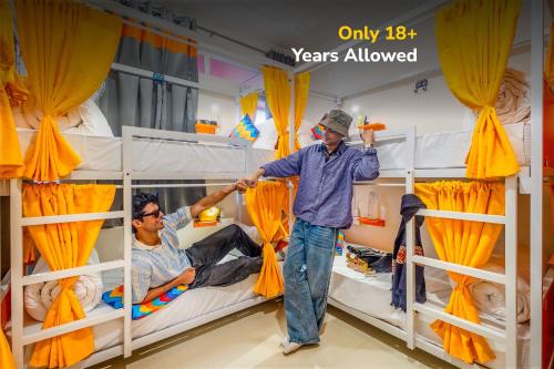 two men standing in a room with bunk beds at goSTOPS Mcleodganj Dalailama Temple in Dharmsala