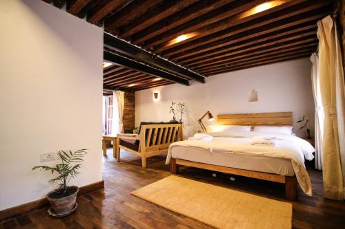 a bedroom with a large bed and a chair at Balcony apartment- 50m from Patan Durbar Sq in Pātan