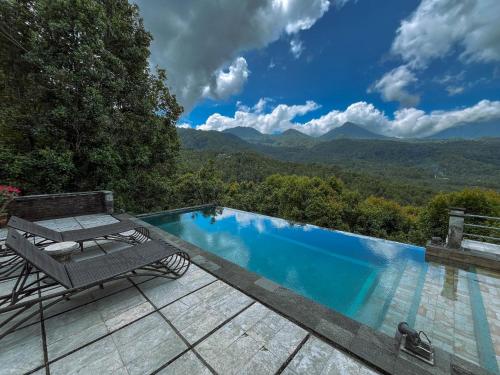 a swimming pool with a table and a bench on a patio at Puri Alam Bali in Munduk
