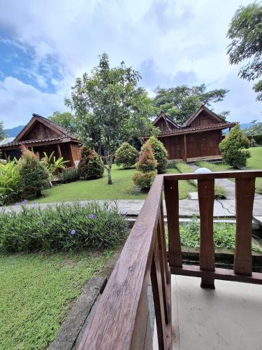 a wooden bench in front of a house at Balkondes Tuksongo in Borobudur