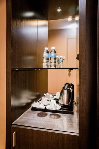 a kitchen with a stove with a tea kettle on it at Green Sun Hotel in Manila