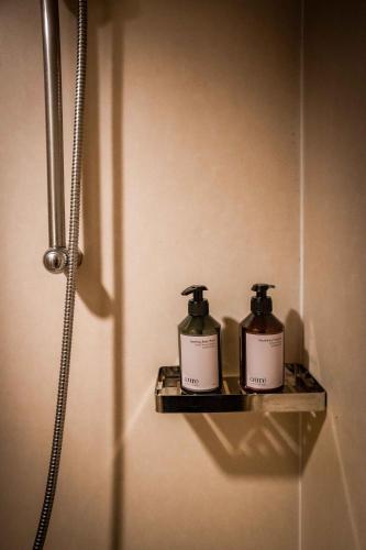 two bottles of soap sitting on a shelf in a bathroom at Green Sun Hotel in Manila