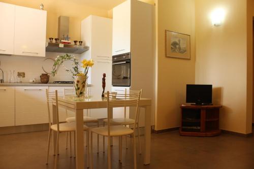 une cuisine avec une table et des chaises et une télévision dans l'établissement Casale La Barca, à Albinia
