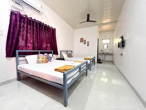 2 łóżka w pokoju z fioletowymi zasłonami w obiekcie Karjat In Resort By Karjat Stays w mieście Karjat