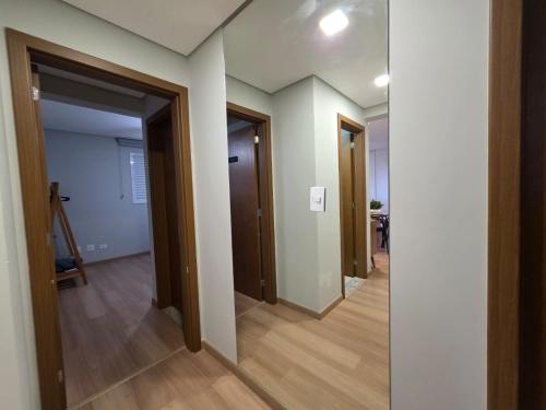 an empty hallway with two doors and a room with wood floors at Maringá, Zona 07 - seu local de conforto e conveniência in Maringá