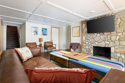 a living room with a couch and a stone fireplace at Dyer Lake Gallery Retreat - Lakefront - Deck - Fire Pit in Grawn