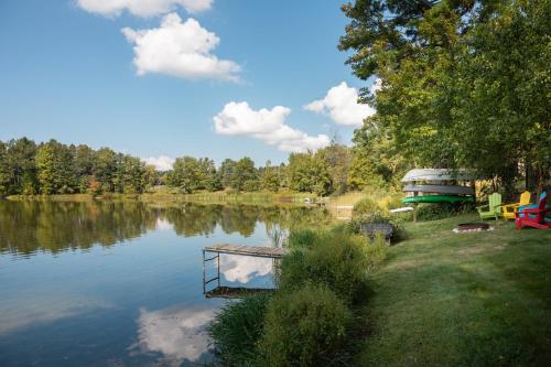 a lake with a boat in the middle of it at Dyer Lake Gallery Retreat - Lakefront - Deck - Fire Pit in Grawn