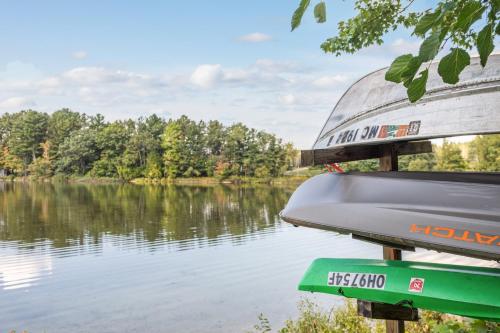 a boat on a lake with trees in the background at Dyer Lake Gallery Retreat - Lakefront - Deck - Fire Pit in Grawn