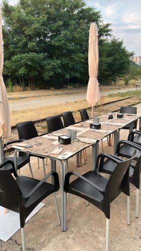 a group of tables with chairs and an umbrella at El Vagón Bar-Albergue Béjar in Béjar