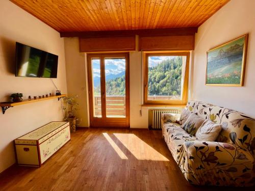 Una sala de estar con un sofá y una ventana grande. en Casa DaRin, en Vigo di Cadore