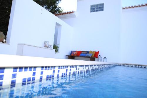 a swimming pool next to a white building at Vila Louro in Santa Cruz