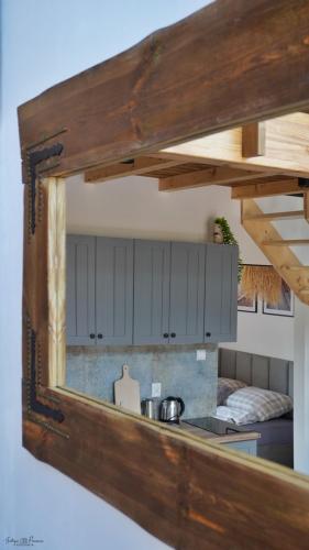 a mirror hanging on a wall in a kitchen at Nasza Osada in Firlej