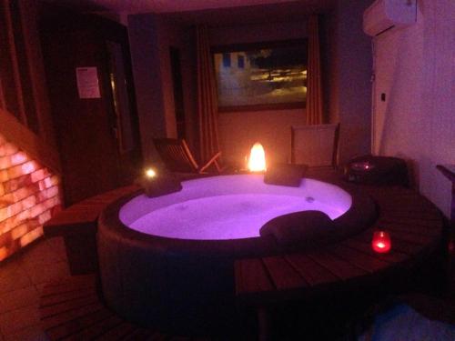 a bathroom with a large tub with a candle in it at Il Maiolandro in Noasca
