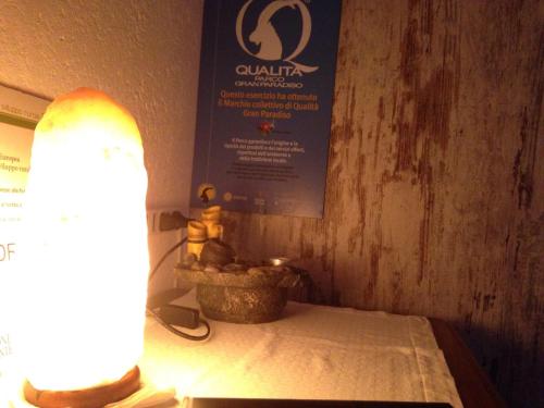 a table with a sign on the wall and a bowl of fruit at Il Maiolandro in Noasca