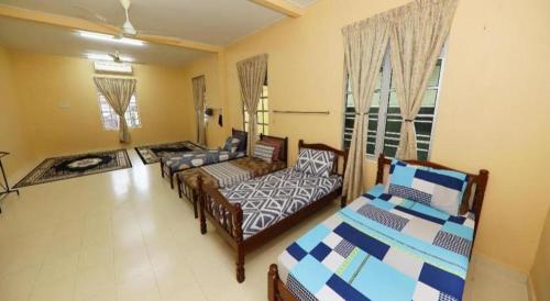 a living room with two beds and a couch at OYO 91004 Homestay Masjid At Taqwa (Syariah) in Kota Bharu