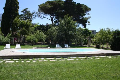a swimming pool with lounge chairs in the grass at Castello di Casamassella - Marea Stays Collection in Casamassella