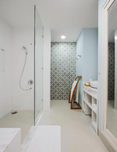 a white bathroom with a shower and a sink at The Cliff Resort & Residences in Mui Ne