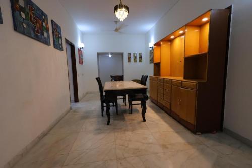 a dining room with a table and a cabinet at Imperial Home Stayz in Gurgaon