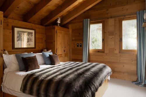 a bedroom with a bed in a log cabin at Chalet Jenna Verbier - by EMERALD STAY in Verbier