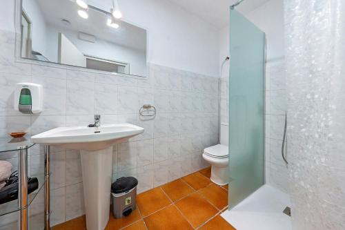 a white bathroom with a sink and a toilet at Lo Perxe in Villalba dels Arcs